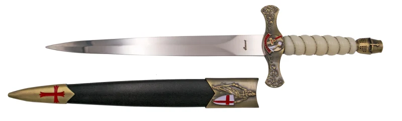 Daga Templaria S0296, el pomo está acabado con un casco en bronce antiguo y el mango en acrílico blanco con hilo metalico torneado en bronce, la guarda acabada en bronce antiguo con relieves y detalle en el medallón dentral. El tamaño total es de 40 cm con hoja de acero. La vaina está acabada en plástico negro con los detalles metálicos en bronce antiguo con las cruzes pintadas en rojo. Ref. S0296