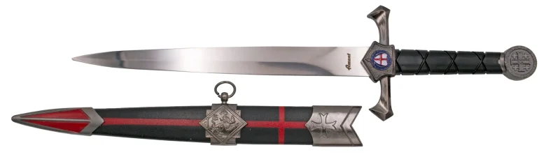 Daga Templaria S0300, el pomo está acabado en níquel y el mango en plástico negro, la guarda acabada en níquel con un escudo templario. El tamaño total es de 40 cm con hoja de acero. La vaina está acabada en plástico negro con una cruz en rojo con los detalles metálicos en níquel. Ref. S0300